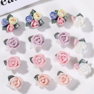 Macro view of colorful resin rose charms with green leaves for DIY jewelry making