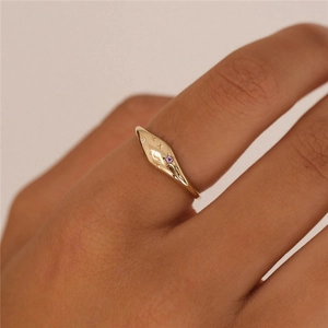 Detailed view of a gold S925 ring featuring purple stone and star engraving on finger