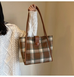 Brown and beige plaid wool tote bag on model shoulder with soft knit sweater