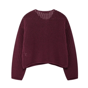 Macro detail of wine red chunky knit sweater showing hollow crochet texture and buttons