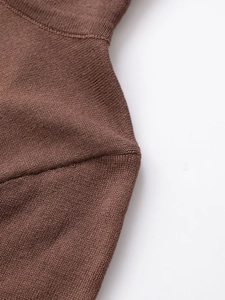 Détail de la couture d'épaule et texture en maille fine sur haut asymétrique à col montant