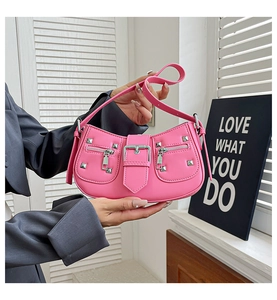 Macro detail of pink leather motorcycle bag featuring metal rivets and buckle straps