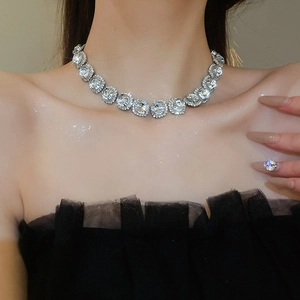 Close-up of a silver floral necklace with clear crystals worn by a female model