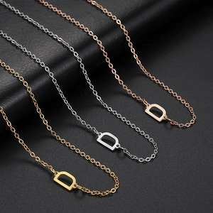 Three minimalist letter D pendant necklaces in gold, silver, and rose gold stainless steel
