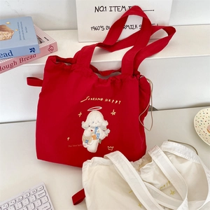 Detail of red and white canvas tote bag featuring cute cartoon animal embroidery and drawstring