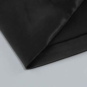 Gros plan sur un tissu en satin noir de haute qualité avec texture fine et reflets