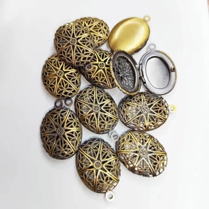 Macro view of vintage hollow oval locket pendants in bronze with one open showing interior