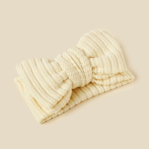 Close-up of cream knit baby headband with plush texture and bow detail