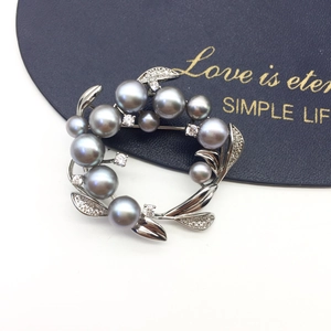 Close-up of grey freshwater pearl brooch with silver leaves and sparkling rhinestones