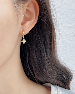 Elegant gold clover hoop earrings with pavé stones on a model for a minimalist luxury look