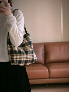 Détail d'un sac cabas en laine à carreaux vintage montrant la texture et les tons d'automne