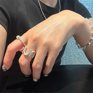 Close-up of minimalist S925 sterling silver U-shaped ring and beaded bracelet set