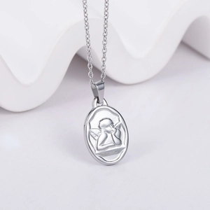Detailed view of an oval silver cherub relief pendant on a minimalist steel chain