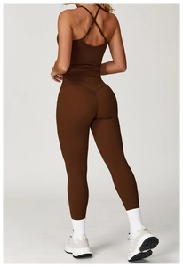 Dettaglio del reggiseno sportivo con incrocio e legging a vita alta moka