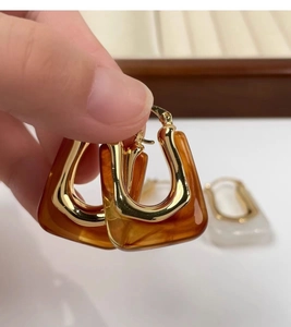 Detailed macro view of 18K gold plated U-shaped amber resin earrings in vintage style