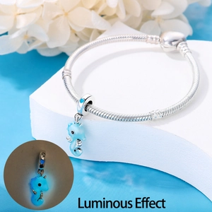 Detailed view of silver seahorse charm on snake chain with luminous glow effect