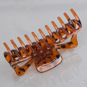 Macro detail of large amber tortoise shell hair claw clip with strong grip teeth