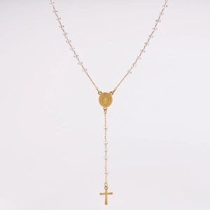 Detail of a long gold crystal rosary necklace with transparent beads and a cross pendant