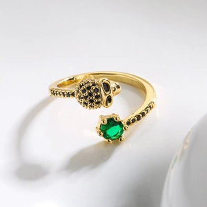 Punk skull open ring in gold with black pavé zircons and a green gemstone focal point