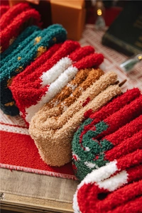 Détail de chaussettes de Noël douillettes en polaire aux couleurs de fête sur bois