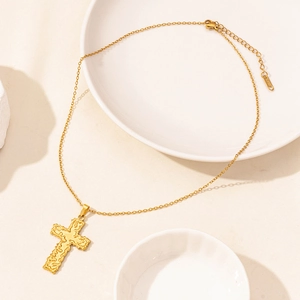 Detailed macro view of gold-plated stainless steel cross pendant and adjustable link chain