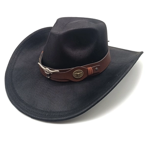 Detail of western cowboy hat featuring brown leather band and silver bull skull ornament