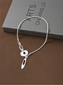 Detail of silver irregular pendant with brown inlay and black bead on snake chain
