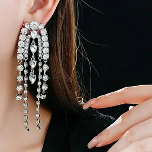 Silver needle teardrop earrings with long crystal tassels shown on a model