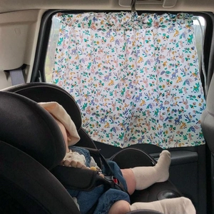 Detailed view of white fabric car sunshade with colorful deer pattern on window