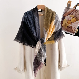Close-up of colorful checkered scarf with fringe detail on a cream white coat