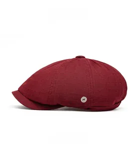 Side view of a burgundy newsboy cap featuring breathable mesh fabric and a silver metal button