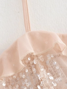 Detail of light pink sequined camisole top with ruffle trim and sheer tulle straps