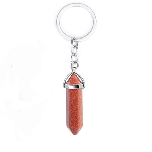 Macro shot of natural red sandstone hexagonal prism pendant on silver keychain