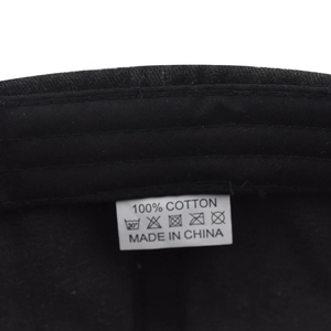 Macro detail of washing label showing 100% cotton material on washed denim baseball cap
