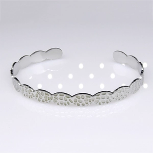 Detail of silver stainless steel cuff bracelet with unique organic wave texture