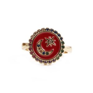 Macro view of gold-tone ring featuring red enamel, moon star motif and colorful crystals