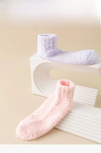 Detail view of plush coral fleece home socks in soft purple and pink colors