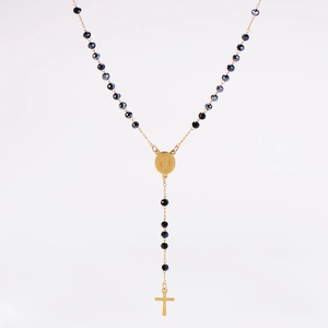 Détail du chapelet avec perles noires facettées, médaille ovale dorée et croix