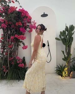 Detail of elegant yellow lace maxi dress featuring backless design and fishtail silhouette