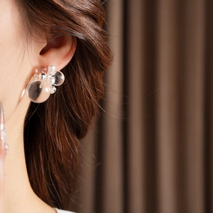 Close-up of clear bubble earrings with faux pearls on a model for a vintage look