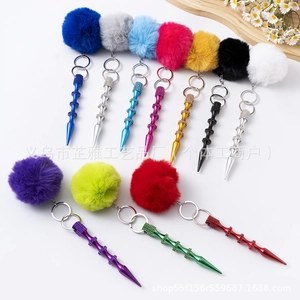 Detail of colorful faux fur pompom keychains with textured metal spikes in various colors
