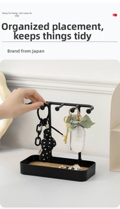 Detailed shot of a black metal jewelry organizer with a wooden base for keys and accessories
