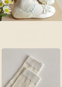 Detail of cream white ribbed socks and ballet flats with elastic logo band and bow