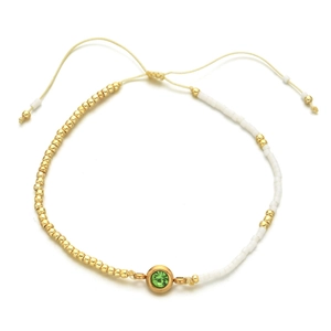 Detail of adjustable beaded bracelet with green crystal and gold-tone accents