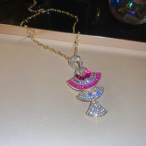 Macro shot of gold fan pendant necklace with pink blue gems and sparkling rhinestones