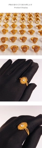 Detail showing gold-plated sunflower ring with zircon stone and triple-band weave design