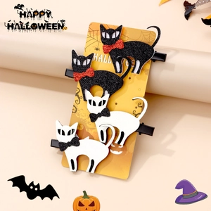 Set of four Halloween cat hair clips with glitter bows on festive display card