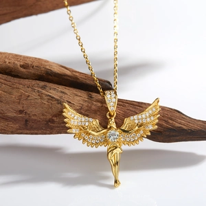 Macro shot of gold angel wing pendant with sparkling pavé stones on rustic wood background