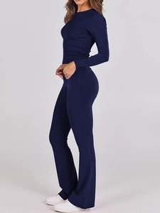 Dettaglio del top a maniche lunghe blu navy attillato e dei pantaloni in maglia svasati
