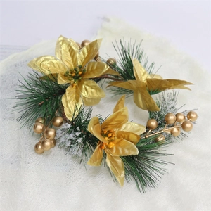 Christmas wreath with gold poinsettias, green pine needles and berries on white plush
